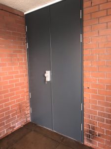 Tall black security doors with silver handles