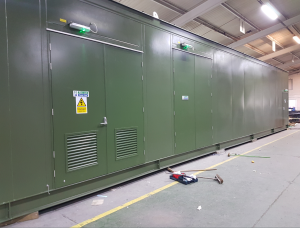 Green metal building in a warehouse with large silver roller door