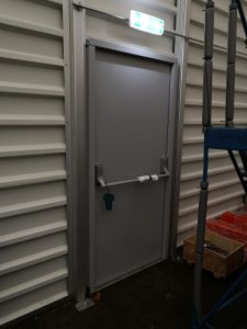 Grey security door with a pushbar handle