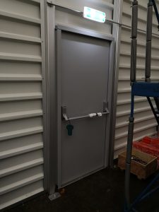 Grey security door with a pushbar handle