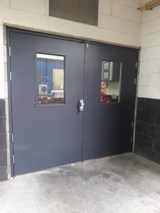 Double wide balck security doors with windows and a silver handle