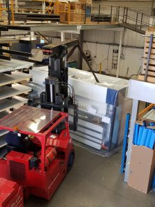 Large machine with a red forklift ahead of it
