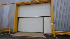 Large roller door with smaller roller door and steel security below