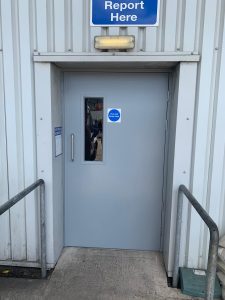 Grey security door outside a white metal building