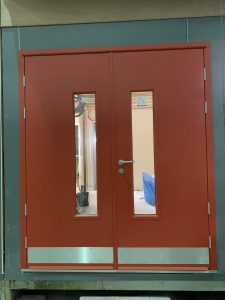 Orange steel door with a window in a blue room