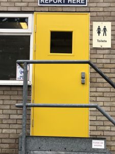 Yellow steel door at the top of a staircase