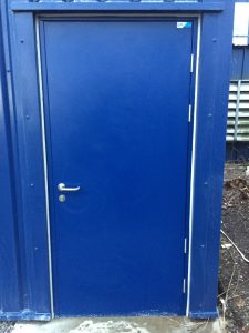 Blue steel door outside a blue building
