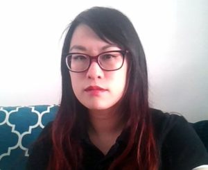 Woman in a black shirt and glasses looking ahead