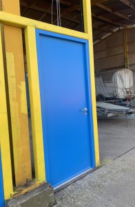 Blue security door on a yellow framed building
