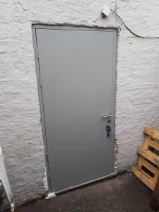 Grey security door in a white room