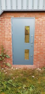 Grey security door with a silver handle leading outside