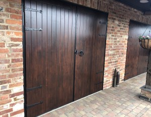 Old styled brown double wooden doors with black handles and hinges