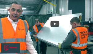 Video thumbnail showing men in high visibility clothing holding a large piece of metal