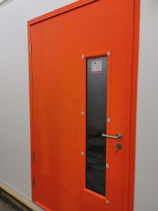 Red security door with a frosted glass panel and a silver handle