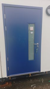 Blue steel security door with frosted glass panel and a silver handle
