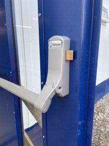 Close up of a blue security door with a push handle