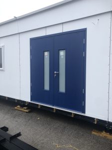 Black double security doors on a white building
