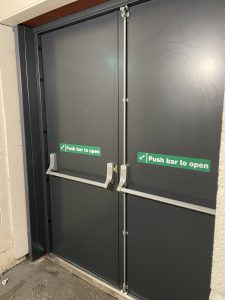 Black double security door with push bars to open