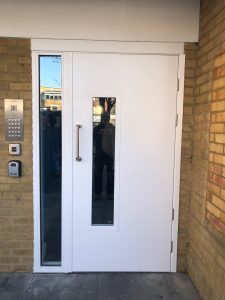White door with a silver handle with a keypad to the left