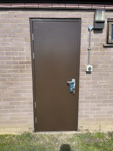 Black security door with a silver handle and keys hanging
