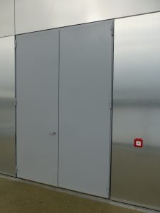 Grey steel security Door surrounded by metal panelling