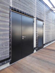 Black steel doors surrounded by metal linkage