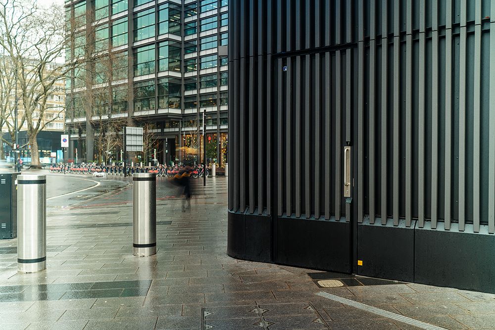 Metador's metal doors installed in an architectural building in London. Featuring dark grey batons that seamlessly integrate with the building's façade on a busy street.