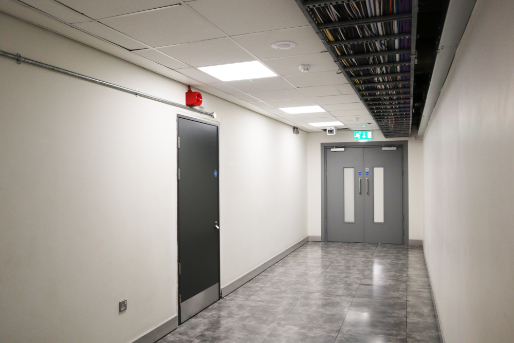 Internal fire rated double steel doorset in data centre with two vision panels at the end of a hallway