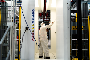 Powdercoating plant worker at Metador Ltd applying a finish to a steel doorset inside of the spray booth
