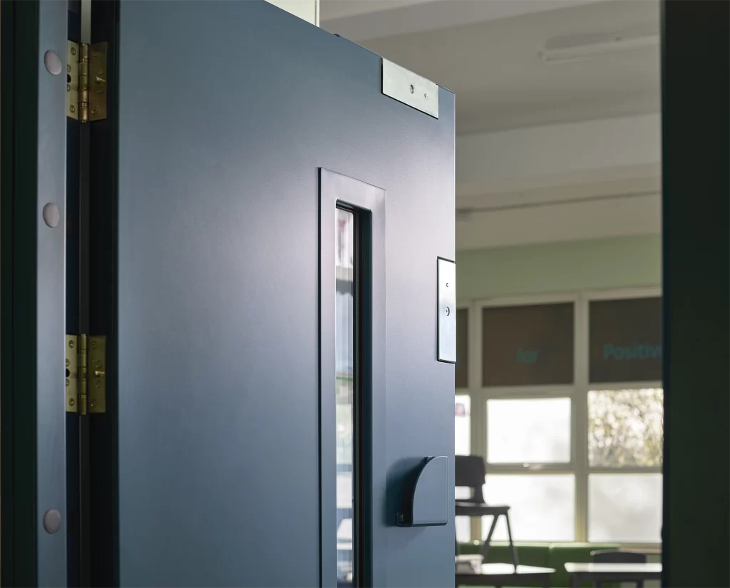 Metador steel doorset featuring Maglocks to door leaf and steel quadrant handle with vision panel