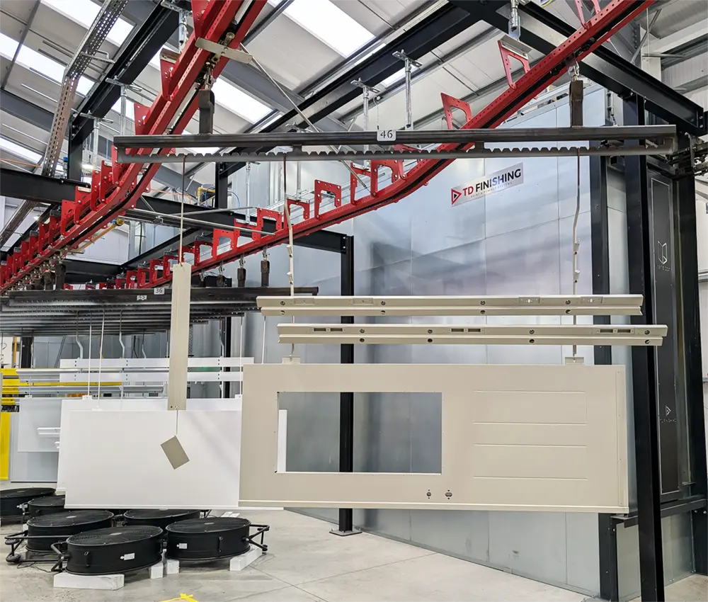 Steel doorset being powder-coated in Pebble Grey in-house at Metador's manufacturing facility